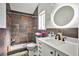The remodeled bathroom has a custom vanity, stylish fixtures, modern lighting, and walk-in shower with updated tile at 4438 Faberge Ave, Las Vegas, NV 89115