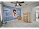 The bedroom features tile flooring, a ceiling fan, custom paint, and dresser with storage at 4438 Faberge Ave, Las Vegas, NV 89115