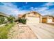 Beige single-story home featuring a two-car garage and a concrete driveway with green front lawn at 4438 Faberge Ave, Las Vegas, NV 89115