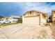 Beige single-story home featuring a two-car garage and a concrete driveway under a cloudy blue sky at 4438 Faberge Ave, Las Vegas, NV 89115