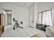 Bright living room boasts white walls, tile floors, exercise bike, and a view of the hallway and front door at 4438 Faberge Ave, Las Vegas, NV 89115