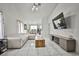 Open concept living room featuring tile floors, stylish sofa, a modern entertainment center, and dining area at 4438 Faberge Ave, Las Vegas, NV 89115