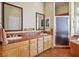 Bathroom with double sink vanity, tiled countertops and floors, and a glass-enclosed shower at 4574 Sheri Lyn Ct, Las Vegas, NV 89121