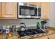 Granite countertops with stainless steel microwave and stovetop in a cozy kitchen with wooden cabinets at 4574 Sheri Lyn Ct, Las Vegas, NV 89121