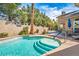 Refreshing pool with steps, surrounded by lush greenery and a serene patio area with outdoor seating at 4574 Sheri Lyn Ct, Las Vegas, NV 89121