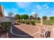 Well-manicured backyard features desert landscaping with a bench and privacy fencing at 5433 Honey Mesquite Ln, Las Vegas, NV 89130