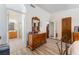 A well-lit bedroom leading to a bath with a dresser, wood floors and bright, neutral paint at 5433 Honey Mesquite Ln, Las Vegas, NV 89130