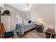 Cozy bedroom features wood-style flooring, neutral paint, ceiling fan, and a sitting area at 5433 Honey Mesquite Ln, Las Vegas, NV 89130