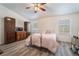 Comfortable bedroom featuring wood-style floors, natural light, and wooden dresser and cabinets at 5433 Honey Mesquite Ln, Las Vegas, NV 89130