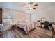 Bright bedroom with a ceiling fan, wood-style floors, a large desk and neutral paint at 5433 Honey Mesquite Ln, Las Vegas, NV 89130