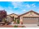 Front exterior view of a single-story home with desert landscaping and a two-car garage at 5433 Honey Mesquite Ln, Las Vegas, NV 89130