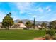 Beautiful view of homes overlooking a lush green common area with mountain backdrop at 5433 Honey Mesquite Ln, Las Vegas, NV 89130