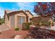 Exterior view of a home with desert landscaping, trees, and neutral stucco at 5433 Honey Mesquite Ln, Las Vegas, NV 89130