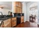Open kitchen with a stainless sink and wooden cabinets, with view to the dining room at 5433 Honey Mesquite Ln, Las Vegas, NV 89130