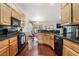 Updated kitchen with black appliances, granite countertops, and wood floors at 5433 Honey Mesquite Ln, Las Vegas, NV 89130