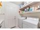 Clean and organized laundry room has washer, dryer, and shelving for storage at 5433 Honey Mesquite Ln, Las Vegas, NV 89130