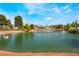 Scenic view of a tranquil pond with a swan and a fountain, surrounded by lush greenery and homes at 5433 Honey Mesquite Ln, Las Vegas, NV 89130