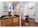 Stylish wet bar area with wood cabinets, a sink, glass shelving and hardwood floors at 5433 Honey Mesquite Ln, Las Vegas, NV 89130