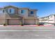 Contemporary townhome showcasing a spacious two-car garage and modern architectural details at 5730 Sky Pointe Dr # 165, Las Vegas, NV 89130
