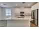 Modern kitchen island with granite countertops, white cabinets, and stainless steel appliances at 5730 Sky Pointe Dr # 165, Las Vegas, NV 89130