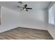Bright living room with wood-look flooring, ceiling fan, and natural light from the window at 5730 Sky Pointe Dr # 165, Las Vegas, NV 89130