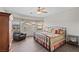 Inviting bedroom with dark wood floors, large window, ceiling fan, and an accent chair at 6022 Quintillion Ave, Las Vegas, NV 89122