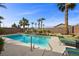 Resort-style pool area with tropical palms, chaise lounges, and clear blue water under a sunny sky at 6022 Quintillion Ave, Las Vegas, NV 89122