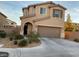 Front exterior of a tan two-story home with desert landscaping and an attached two-car garage at 6563 Pine Hall Ave, Las Vegas, NV 89122