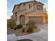 Two-story stucco home featuring an attached two-car garage and low-maintenance desert landscaping at 6563 Pine Hall Ave, Las Vegas, NV 89122