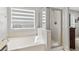 Well-lit bathroom featuring a soaking tub and enclosed glass shower, complemented by natural light at 6653 Ashley House Ct, Las Vegas, NV 89139