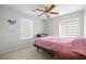 Cozy bedroom with carpeted floors, a bed with pink bedding, and natural light from the window at 6653 Ashley House Ct, Las Vegas, NV 89139