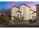 Charming home featuring a well-maintained front yard and eye-catching architectural details and a colorful dusk sky at 6653 Ashley House Ct, Las Vegas, NV 89139