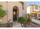 Close up view of the front door, complemented by manicured shrubs and an arched entryway at 6653 Ashley House Ct, Las Vegas, NV 89139