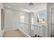 Bright hallway showcasing white railings and neutral walls, with large windows allowing ample light at 6653 Ashley House Ct, Las Vegas, NV 89139