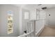 Bright hallway featuring white railings, neutral walls, and a window providing natural light at 6653 Ashley House Ct, Las Vegas, NV 89139
