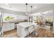 Bright, open kitchen boasts white cabinets, marble counters, and a central island with seating at 6653 Ashley House Ct, Las Vegas, NV 89139