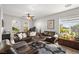 Bright living room with a ceiling fan, ample seating, and views of the landscaped yard at 6653 Ashley House Ct, Las Vegas, NV 89139