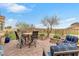 Outdoor patio with a dining table, lounge chairs, and an attractive landscape with a distant mountain view at 69 Via Di Mello, Henderson, NV 89011