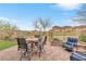 Backyard featuring a patio dining set, lounge chairs, and a serene view of the desert landscape at 69 Via Di Mello, Henderson, NV 89011