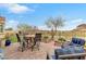Outdoor living space featuring a dining set, chairs, and well-manicured landscaping with a distant mountain view at 69 Via Di Mello, Henderson, NV 89011