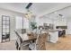 An open concept floor plan with a dining area featuring a wooden table, designer chairs, and views into the kitchen space at 69 Via Di Mello, Henderson, NV 89011