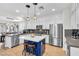 Gourmet kitchen featuring stainless steel appliances, white cabinetry, central island and an adjacent dining area at 69 Via Di Mello, Henderson, NV 89011