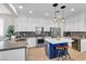 Bright kitchen featuring white cabinets, stainless steel appliances, a central island with seating, and modern pendant lighting at 69 Via Di Mello, Henderson, NV 89011