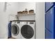 Convenient laundry room featuring modern washer and dryer units with shelving and cabinet storage at 69 Via Di Mello, Henderson, NV 89011