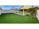 Green backyard with artificial grass, covered patio, landscaping, and privacy wall at 7341 Girard Dr, Las Vegas, NV 89147