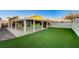 Private backyard featuring an extended covered patio, artificial turf, and ambient string lights at 7341 Girard Dr, Las Vegas, NV 89147
