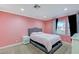 Pink bedroom with a window, carpeted floors, and base molding at 7341 Girard Dr, Las Vegas, NV 89147