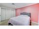 Bedroom with pink walls, carpeted floors, base molding, and a built-in wardrobe at 7341 Girard Dr, Las Vegas, NV 89147