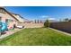 Large backyard with green lawn, brick patio, and play structure, perfect for outdoor activities and relaxation at 7712 Bandon Cliffs St, North Las Vegas, NV 89084