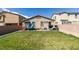 Fenced backyard with a large green lawn, playground, seating, and privacy wall at 7712 Bandon Cliffs St, North Las Vegas, NV 89084
